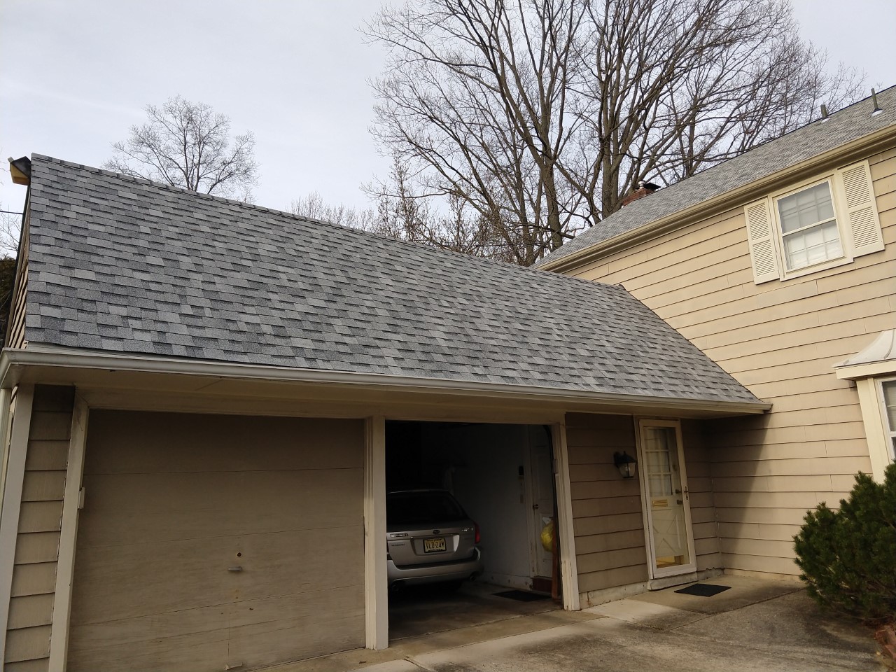 A garage with two cars in it and trees