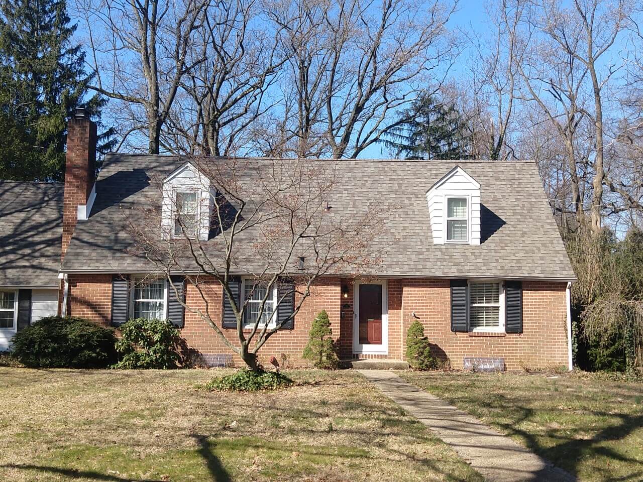 A brick house with a lot of trees in the background